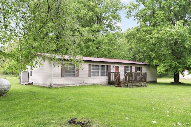 1211 107th Ave, Otsego, MI 49078 - view of front of home featuring a front lawn, a wooden deck, and metal roof