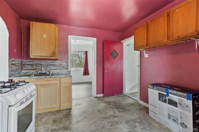 5151 Yemans St, Hamtramck, MI 48212 - kitchen with arched walkways, a sink, white range with gas cooktop, baseboards, and stone finish flooring