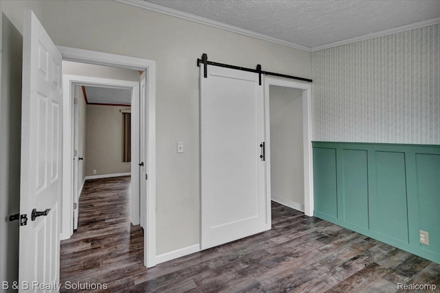 5951 English Rd, Silverwood, MI 48760 - unfurnished bedroom featuring ornamental molding, a barn door, a textured ceiling, dark wood finished floors, and wainscoting