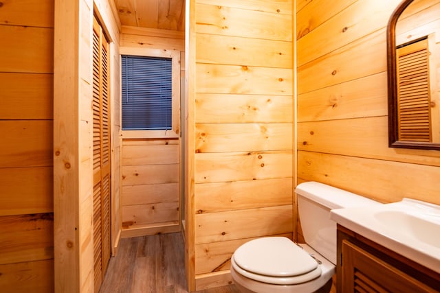 17341 Old Logging Rd, Hersey, MI 49639 - bathroom featuring wood finished floors, toilet, vanity, and wood walls