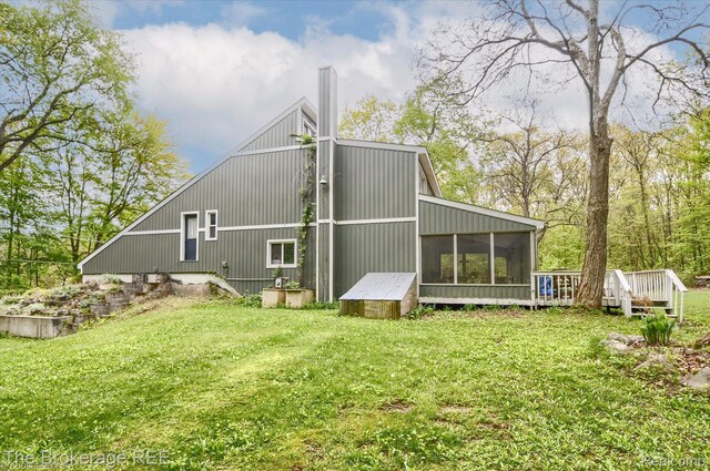 12445 Shaffer Rd, Davisburg, MI 48350 - rear view of house with a sunroom, a yard, and a wooden deck