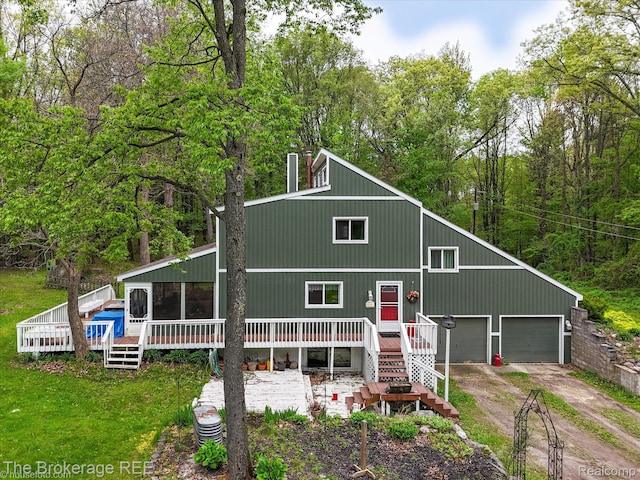 12445 Shaffer Rd, Davisburg, MI 48350 - view of front facade with dirt driveway, a wooden deck, a garage, and a front yard