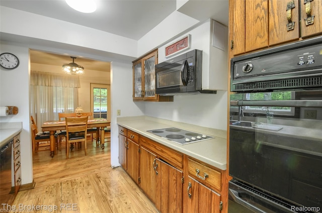 12445 Shaffer Rd, Davisburg, MI 48350 - kitchen with black appliances, light wood-style flooring, brown cabinets, and light countertops