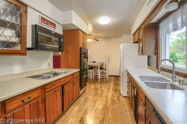 12445 Shaffer Rd, Davisburg, MI 48350 - kitchen with a sink, black appliances, a ceiling fan, light wood-style floors, and brown cabinets