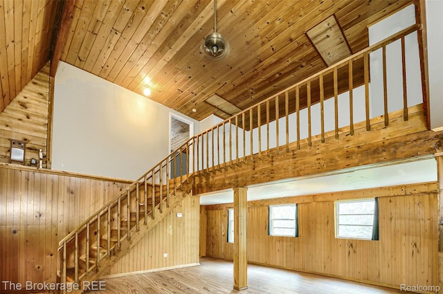 12445 Shaffer Rd, Davisburg, MI 48350 - unfurnished living room with wood finished floors, wood walls, stairway, high vaulted ceiling, and wood ceiling