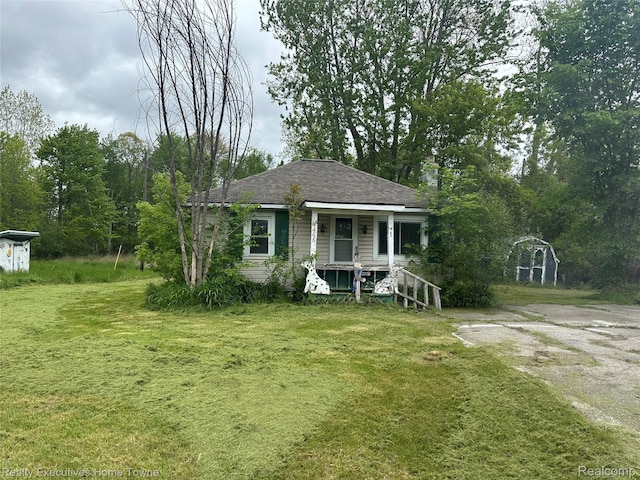 4466 Dove Rd, Saint Clair, MI 48060 - view of front of home featuring a porch, a front lawn, and roof with shingles
