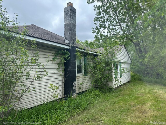 4466 Dove Rd, Saint Clair, MI 48060 - back of property featuring a chimney, a yard, and roof with shingles