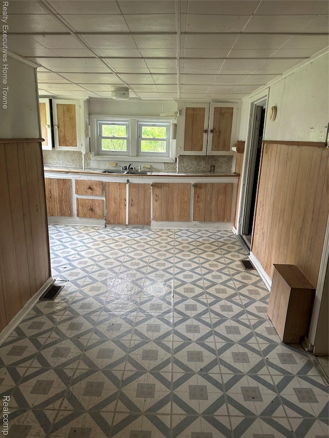 4466 Dove Rd, Saint Clair, MI 48060 - kitchen with light flooring, wood walls, a wainscoted wall, light countertops, and brown cabinets