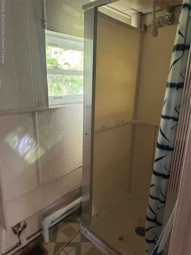 4466 Dove Rd, Saint Clair, MI 48060 - bathroom with a shower stall, tile walls, and tile patterned flooring