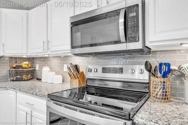 1302 Florida Ave, Port Huron, MI 48060 - kitchen featuring appliances with stainless steel finishes, decorative backsplash, white cabinets, and light stone countertops