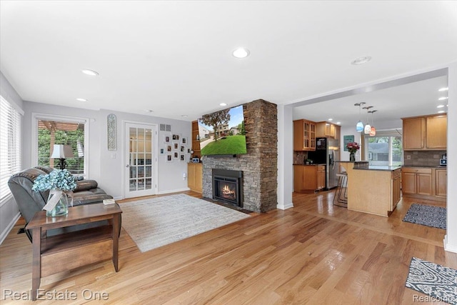 28395 Swan Island Dr, Grosse Ile, MI 48138 - living room with a stone fireplace, light wood-type flooring, baseboards, and recessed lighting