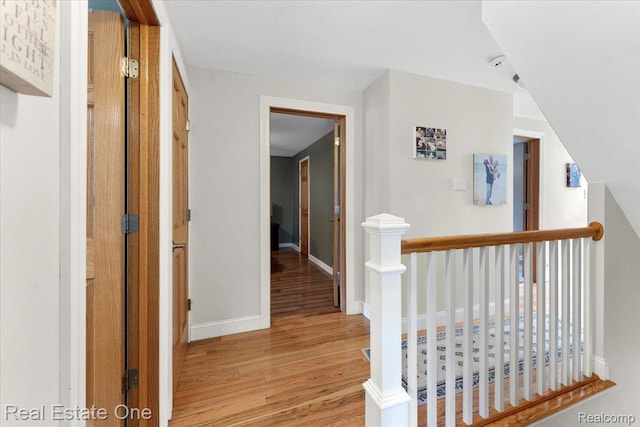 28395 Swan Island Dr, Grosse Ile, MI 48138 - hallway with light wood-type flooring, baseboards, and an upstairs landing