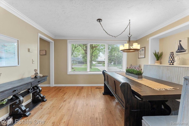 28395 Swan Island Dr, Grosse Ile, MI 48138 - dining area featuring a chandelier, light wood-style floors, crown molding, baseboards, and a textured ceiling