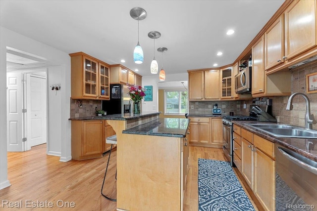 28395 Swan Island Dr, Grosse Ile, MI 48138 - kitchen featuring stainless steel appliances, a sink, a breakfast bar, light wood-style flooring, and recessed lighting