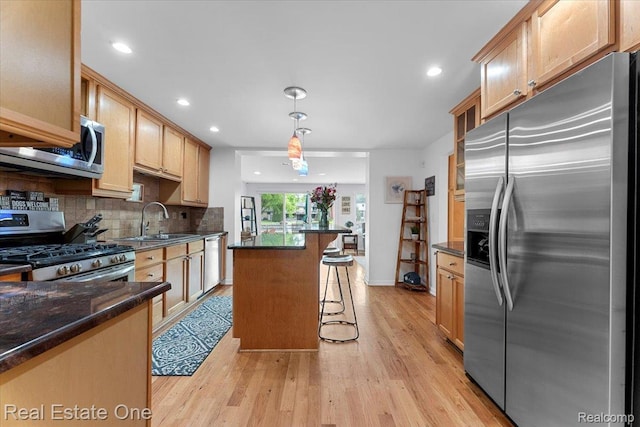 28395 Swan Island Dr, Grosse Ile, MI 48138 - kitchen featuring stainless steel appliances, a sink, a breakfast bar area, decorative backsplash, and light wood-type flooring