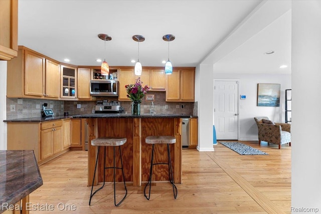 28395 Swan Island Dr, Grosse Ile, MI 48138 - kitchen featuring stainless steel microwave, decorative backsplash, glass insert cabinets, a kitchen breakfast bar, and light wood-style floors