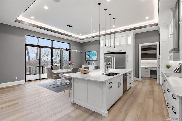 1760 Vista Dr, Oakland, MI 48363 - kitchen with a raised ceiling, light countertops, light wood-style floors, recessed lighting, and a towering ceiling