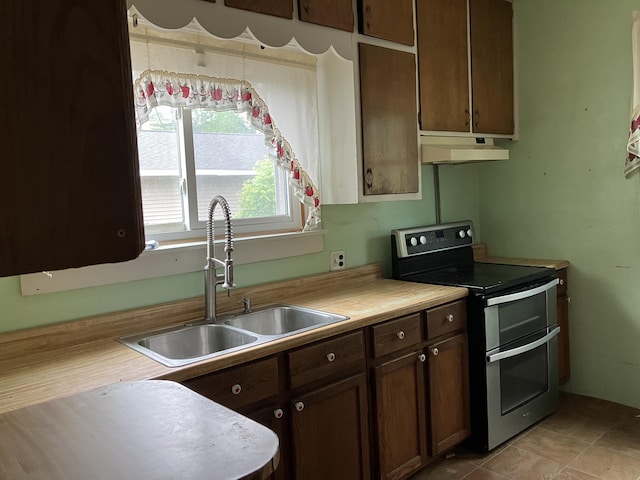 821 Fletcher St, Owosso, MI 48867 - kitchen featuring range with two ovens, under cabinet range hood, a sink, and light countertops