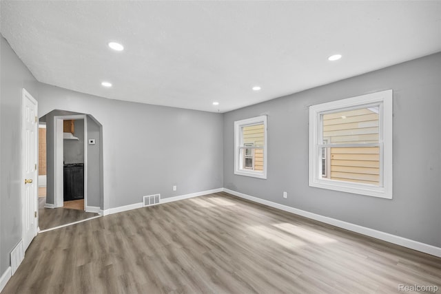 29056 Powers St, Westland, MI 48186 - empty room featuring wood finished floors, arched walkways, recessed lighting, and baseboards