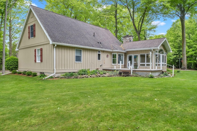 8750 20th Ave, Remus, MI 49340 - back of house featuring roof with shingles, a sunroom, a chimney, and a yard