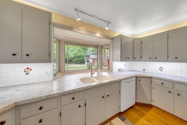 8750 20th Ave, Remus, MI 49340 - kitchen featuring a sink, white dishwasher, light countertops, tasteful backsplash, and a textured ceiling