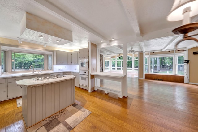 8750 20th Ave, Remus, MI 49340 - kitchen with white appliances, plenty of natural light, ceiling fan, light countertops, and beamed ceiling