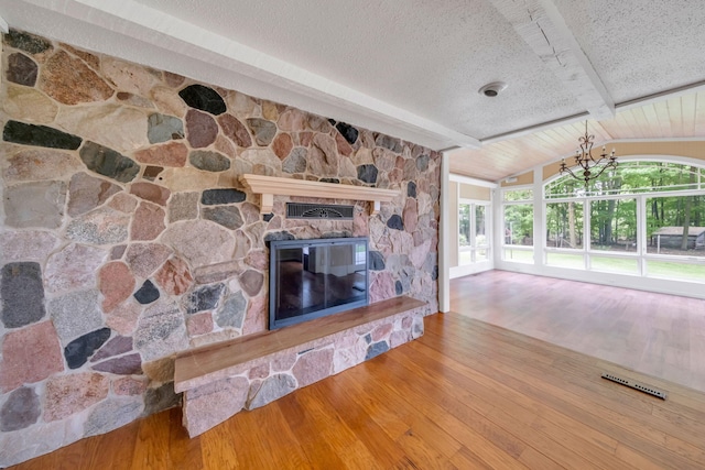 8750 20th Ave, Remus, MI 49340 - living area featuring wood finished floors, a fireplace, a textured ceiling, and a chandelier