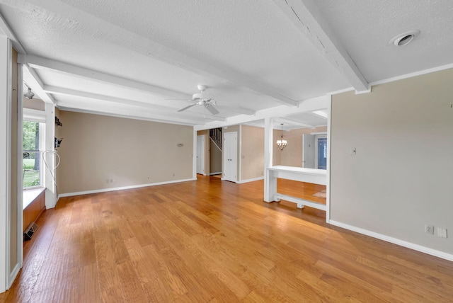 8750 20th Ave, Remus, MI 49340 - unfurnished living room with a textured ceiling, a chandelier, beam ceiling, light wood finished floors, and a ceiling fan