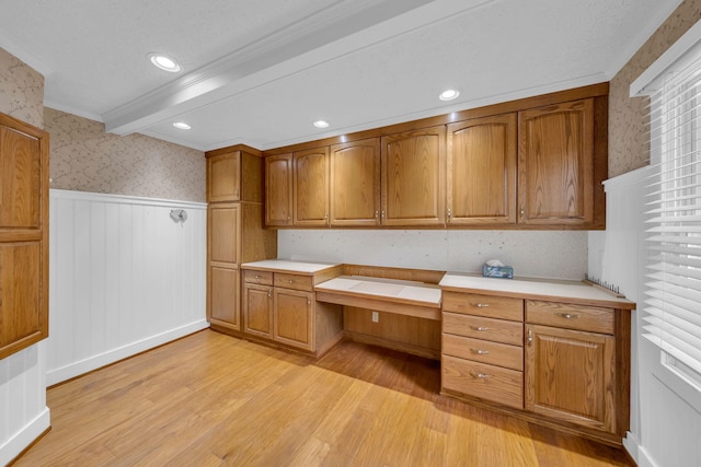 8750 20th Ave, Remus, MI 49340 - kitchen with wallpapered walls, light wood finished floors, a wainscoted wall, brown cabinetry, and light countertops