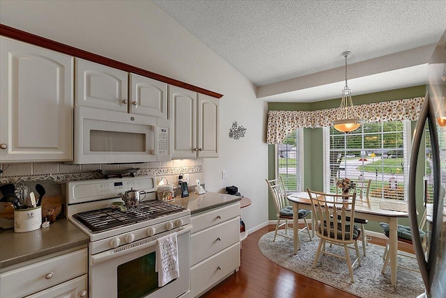3799 Fairway Dr, Norton Shores, MI 49441 - kitchen featuring white appliances, backsplash, vaulted ceiling, pendant lighting, and white cabinets