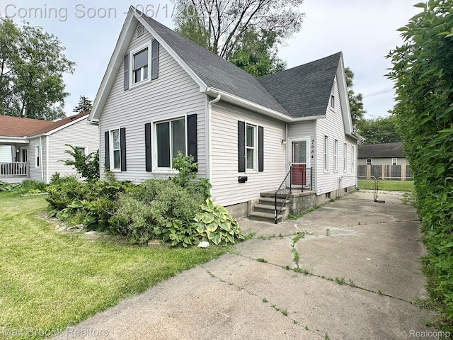 7584 Jackson Ave, Warren, MI 48091 - view of front facade featuring roof with shingles, a front yard, and concrete driveway