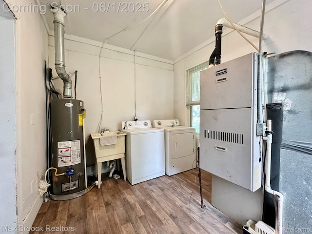 7584 Jackson Ave, Warren, MI 48091 - laundry room featuring washing machine and dryer, water heater, and light wood-style flooring
