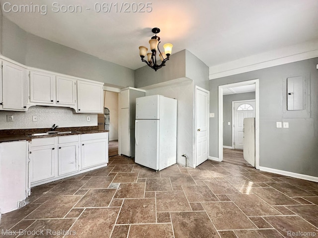 7584 Jackson Ave, Warren, MI 48091 - kitchen featuring freestanding refrigerator, a sink, dark countertops, electric panel, and a chandelier