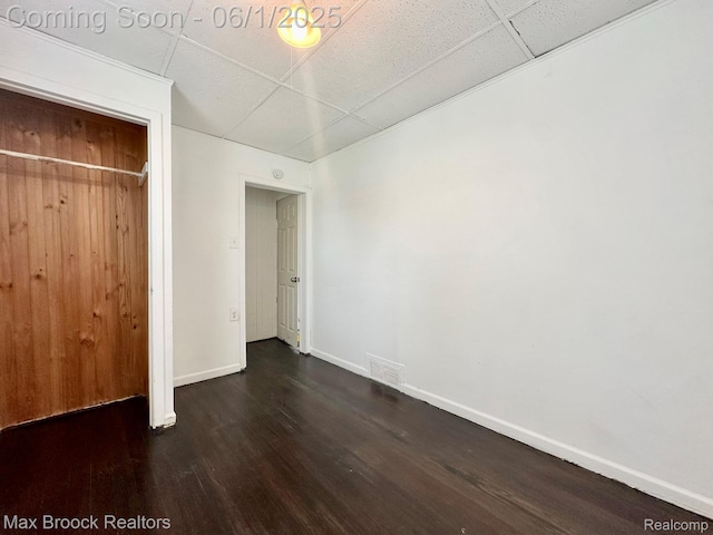 7584 Jackson Ave, Warren, MI 48091 - unfurnished bedroom with dark wood-style flooring, a paneled ceiling, baseboards, and a closet