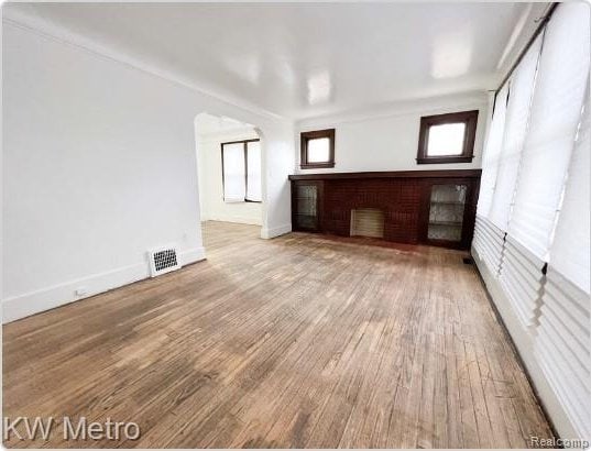 15307 Biltmore St, Detroit, MI 48227 - unfurnished living room with wood finished floors, a fireplace, and baseboards