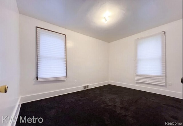 15307 Biltmore St, Detroit, MI 48227 - spare room with healthy amount of natural light, baseboards, and dark colored carpet