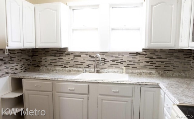 15307 Biltmore St, Detroit, MI 48227 - kitchen featuring white cabinets, a sink, light countertops, and tasteful backsplash