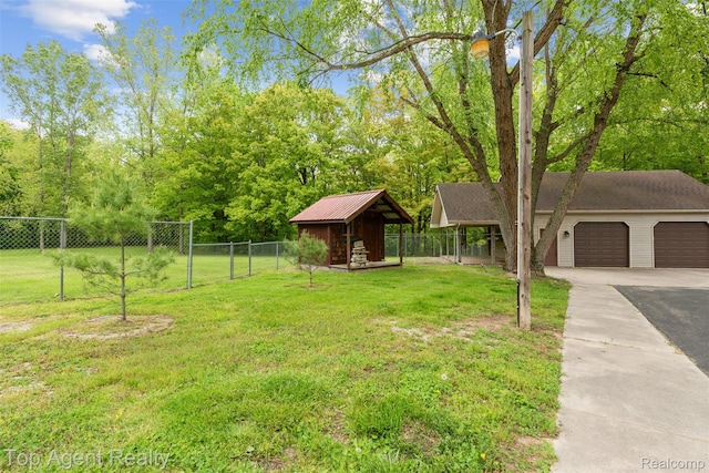 7386 Card Rd, Smiths Creek, MI 48074 - view of yard featuring driveway, an attached garage, an outdoor structure, and view of wooded area