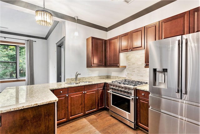 27 Library St NE Unit 301, Grand Rapids, MI 49503 - kitchen with appliances with stainless steel finishes, a sink, light wood-style floors, a peninsula, and light stone countertops