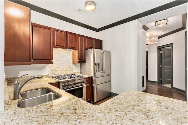 27 Library St NE Unit 301, Grand Rapids, MI 49503 - kitchen featuring a sink, appliances with stainless steel finishes, light stone counters, tasteful backsplash, and dark wood-type flooring
