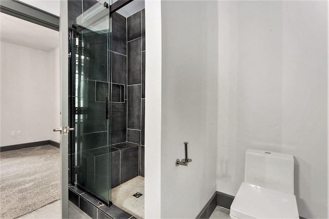 27 Library St NE Unit 301, Grand Rapids, MI 49503 - bathroom with toilet, a stall shower, and baseboards