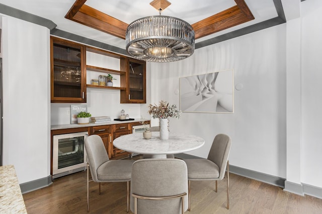 27 Library St NE Unit 301, Grand Rapids, MI 49503 - dining area with wine cooler, a tray ceiling, baseboards, a chandelier, and dark wood finished floors