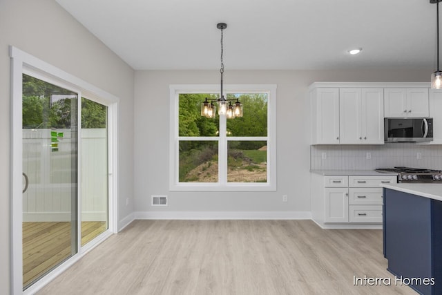 3341 Kings River St SW Unit 40, Wyoming, MI 49418 - kitchen featuring stainless steel microwave, light wood-type flooring, light countertops, a chandelier, and plenty of natural light