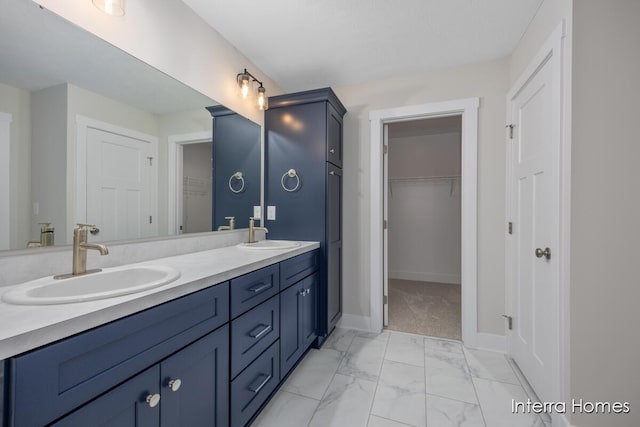 3341 Kings River St SW Unit 40, Wyoming, MI 49418 - bathroom featuring double vanity, marble finish flooring, a walk in closet, and baseboards