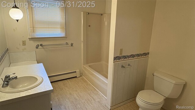 8865 E Bennington Rd, Durand, MI 48429 - bathroom featuring a baseboard heating unit, vanity, toilet, wood finished floors, and  shower combination