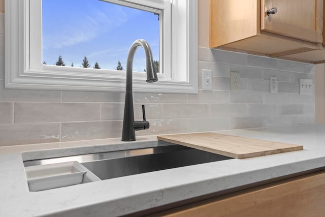 8524 S Elizabeth Dr, Maple City, MI 49664 - kitchen view of backsplash, a sink, and light stone counters