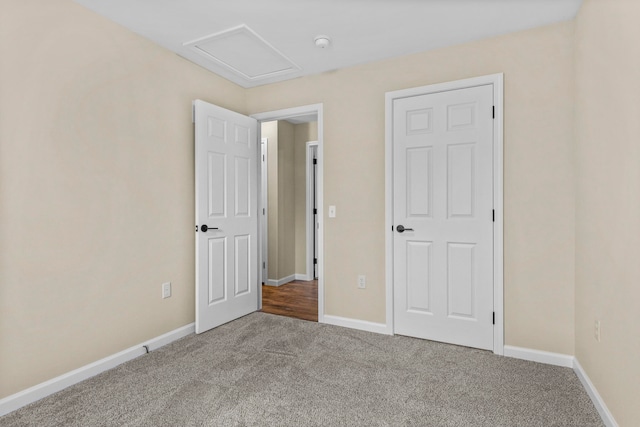 8524 S Elizabeth Dr, Maple City, MI 49664 - unfurnished bedroom featuring carpet flooring, attic access, and baseboards