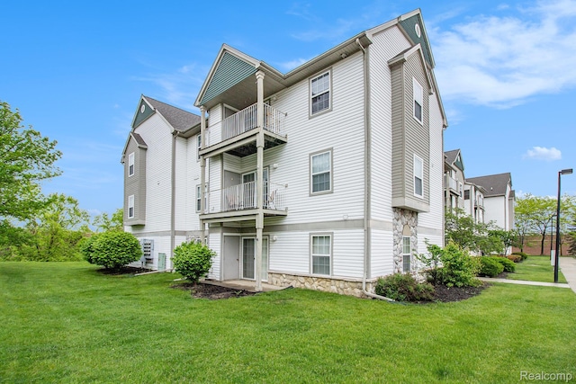15200 Silver Pkwy Unit 101, Fenton, MI 48430 - rear view of property with a balcony and a lawn