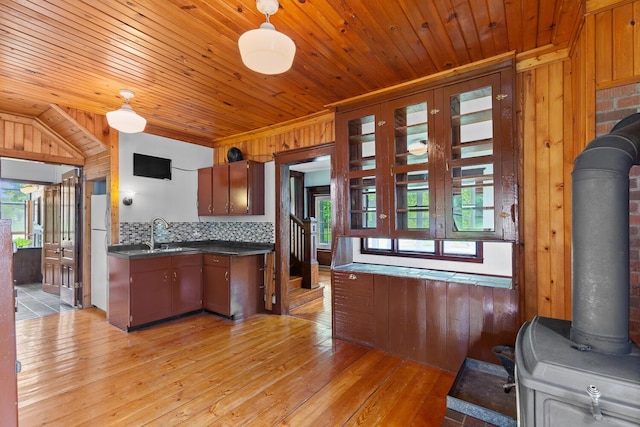 8001 S Jackson Rd, Jackson, MI 49201 - kitchen featuring dark countertops, wooden walls, light wood-style flooring, wood ceiling, and a sink