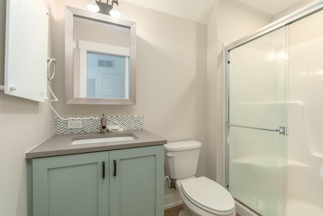 6606 Spaniel Dr, Kalamazoo, MI 49009 - full bathroom featuring toilet, vanity, a shower stall, and backsplash